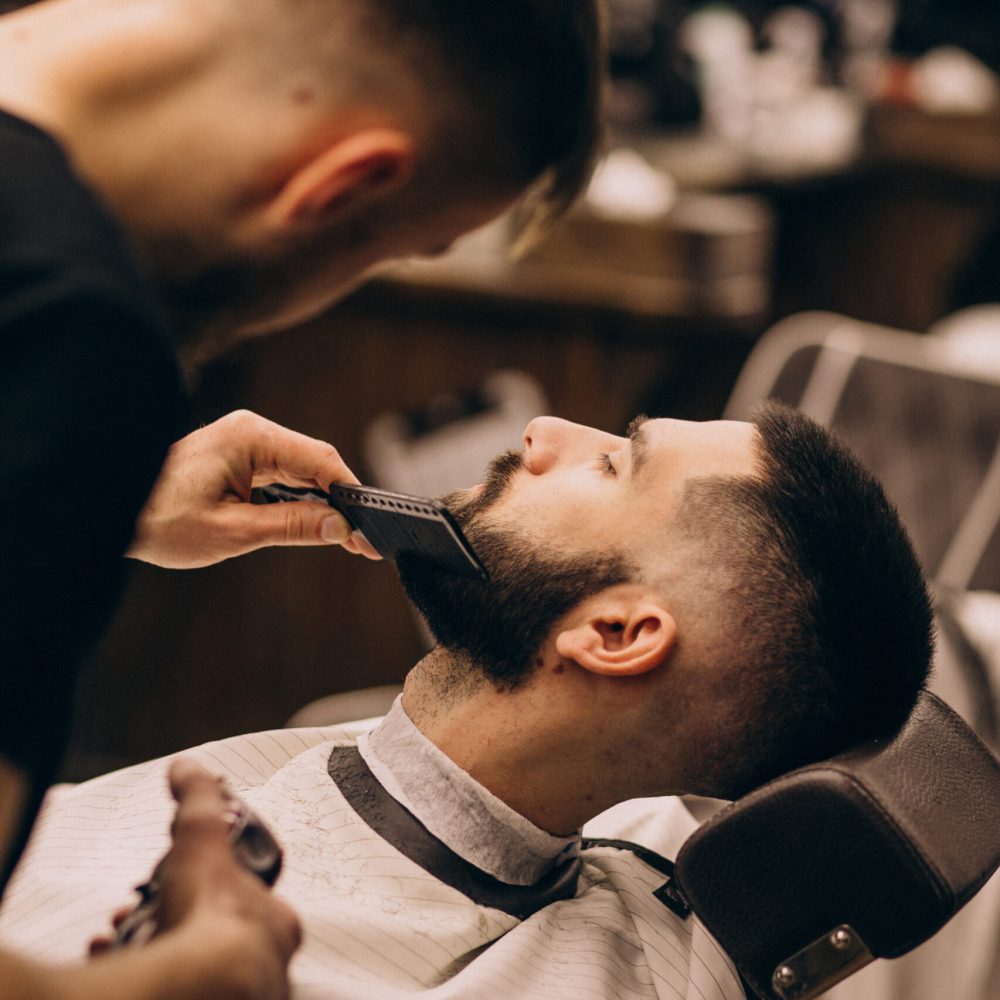 Man at a barbershop salon doing haircut and beard trim