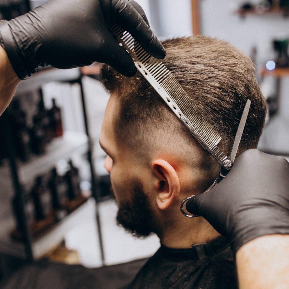 Client doing hair cut at a barber shop salon